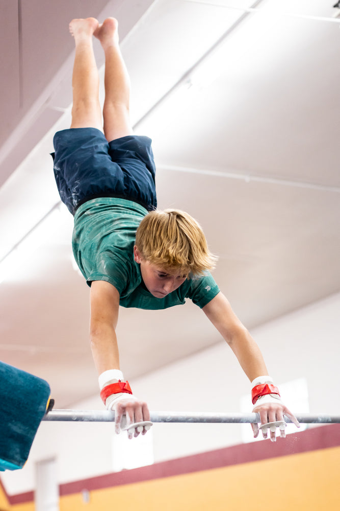 
                  
                    Load image into Gallery viewer, Reisport® Men&amp;#39;s High Bar hook-and-loop grips on boy swinging from gymnastics high bar
                  
                